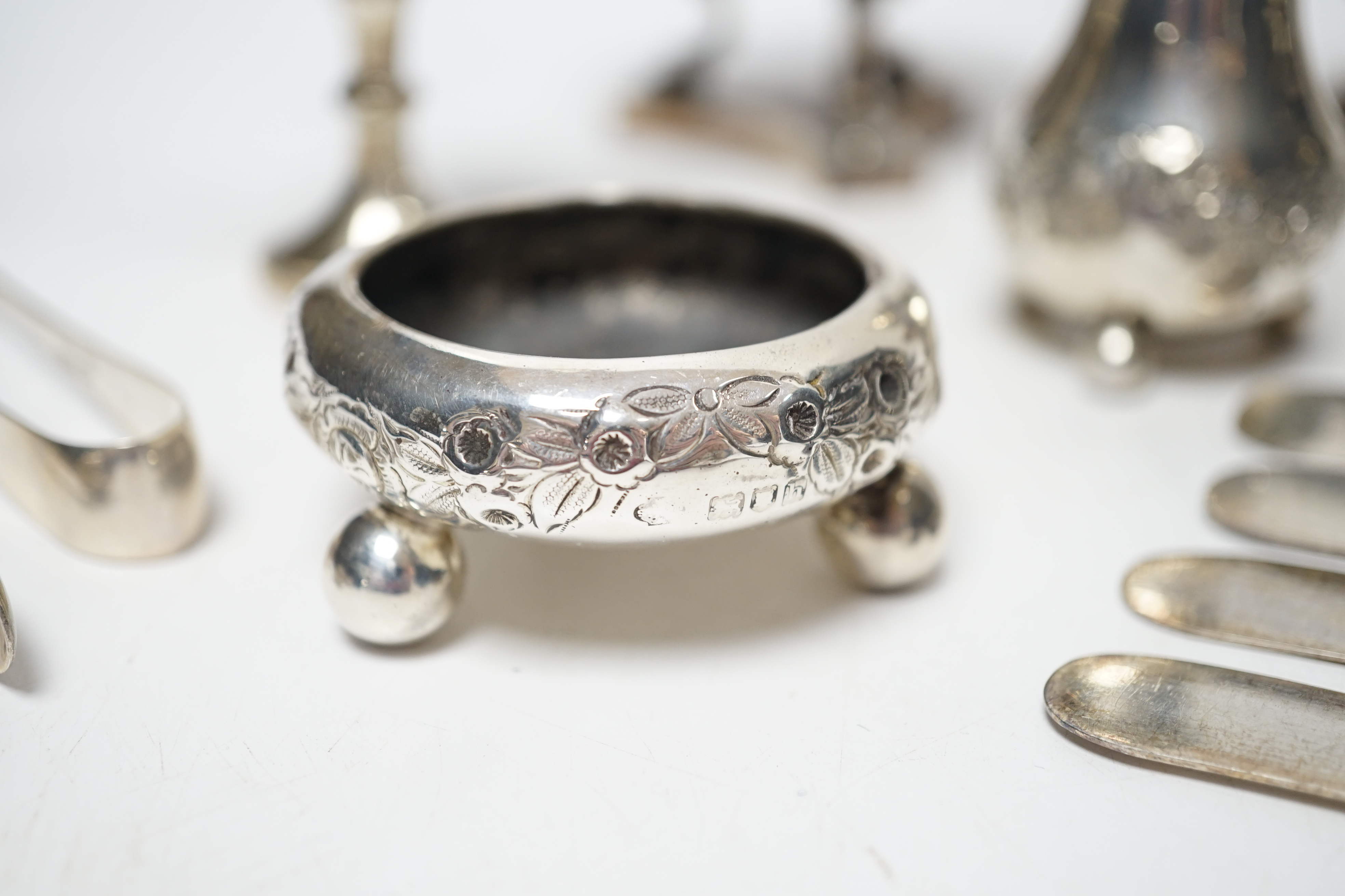 Twelve assorted silver condiments, including a set of four Edwardian bun salts, William Hutton & Sons, London, 1903, a set of six silver handled tea knives, a small silver trophy cup, silver napkin ring, cased silver thi